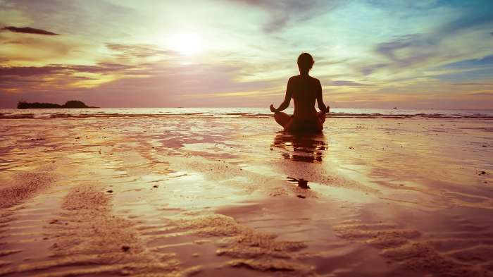 chakra-meditation woman meditating on a sunset beach