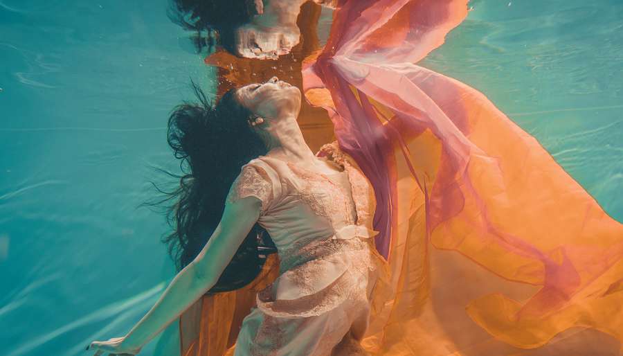 Sun-in-Pisces Woman Underwater in Floaty Orange Dress